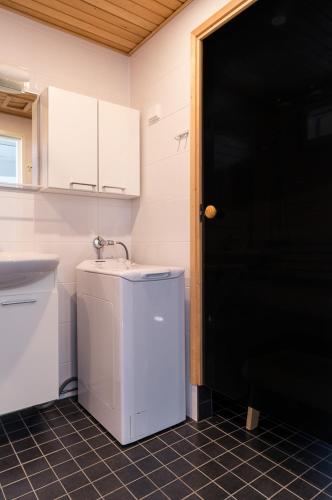 a bathroom with a sink and a black door at Meritähti 104 in Kalajoki