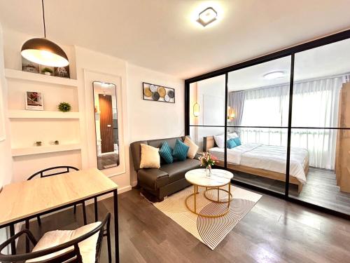 a living room with a couch and a bed and a table at Vibe Old Town 452 in Phuket