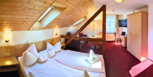 a room with a large bed with white pillows at Hotel-Pension Vier Jahreszeiten in Bad Elster