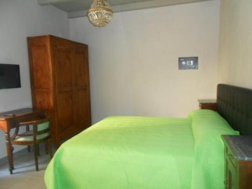 a bedroom with a green bed and a desk at Casa della Valle in Trisobbio