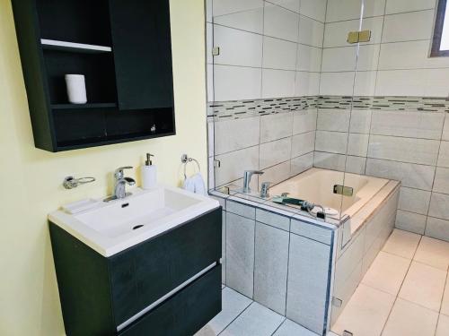 un baño con lavabo y bañera en Beautiful Entire House, en San Pedro