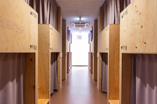 a hallway in a building with wooden boxes at Mezame Hostel in Nagasaki