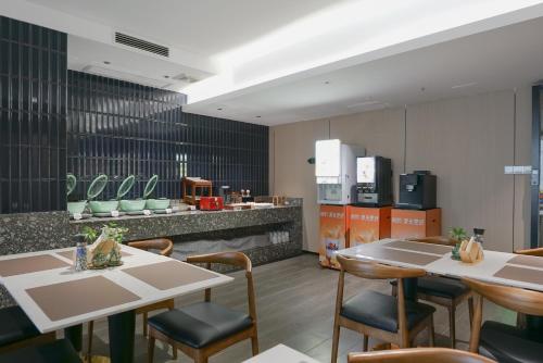 a restaurant with two tables and chairs and a counter at Paco Hotel Tianhe Coach Terminal Metro Satation Guangzhou-Free Shuttle Bus for Canton Fair in Guangzhou