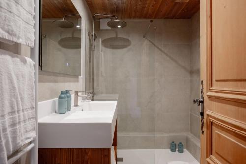 a bathroom with a white sink and a shower at Hôtel Les Roches Fleuries in Cordon