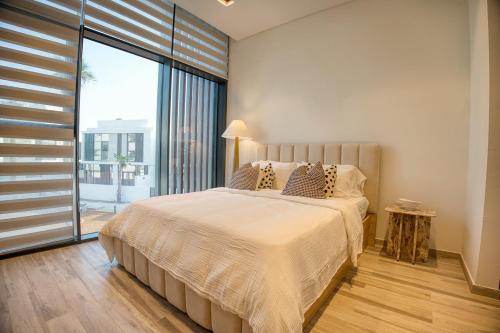 ein Schlafzimmer mit einem großen Bett und einem großen Fenster in der Unterkunft Luxury 3BR Villa with Maid Room & Private Beach Access in Ras al Khaimah
