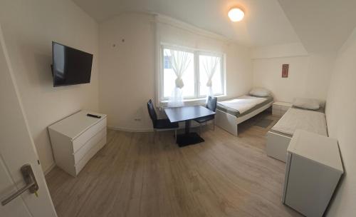 a small room with a bed and a desk with a table at deSoL in Forst
