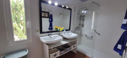 a bathroom with two sinks and a shower and a mirror at LORO PARQUE PUERTO DE LA CRUZ in Puerto de la Cruz