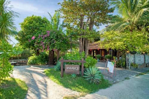 a garden with a sign in front of a house at Mayci Eco Boutique Hotel Hoi An in Hoi An