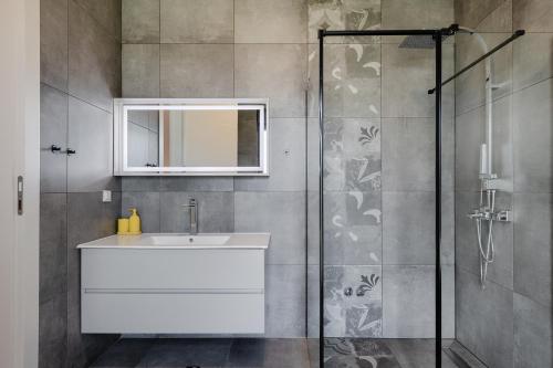 a bathroom with a sink and a shower at Villa BB Rapsody 10 with heated salt water pool in Butkovići