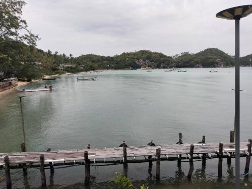 a dock on a lake with boats in the water at Laem Klong sae view in Koh Tao