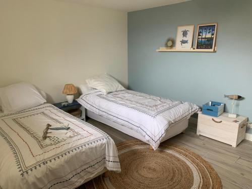 a bedroom with two twin beds and a rug at Séjour Entre Océan et Centre-Ville in Hossegor