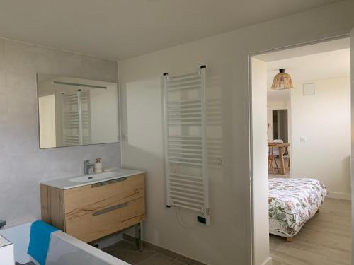 a bathroom with a sink and a mirror at Séjour Entre Océan et Centre-Ville in Hossegor