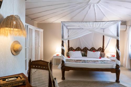 a bedroom with a canopy bed in a room at Crystal Bay Resort in Watamu
