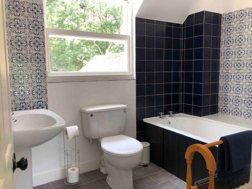 une salle de bain avec toilettes, baignoire et lavabo dans l'établissement Poole Manor House, à Lytchett Matravers