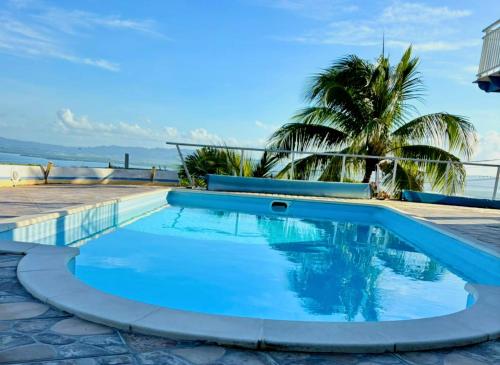 a swimming pool with a view of the ocean at Ti-Garence vue mer in Les Trois-Îlets