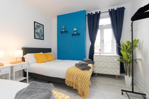 a bedroom with a bed and a blue wall at Open Mind Property - 4BR, 17 Guests & Free Parking in Portsmouth