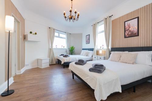 a bedroom with two beds and a chandelier at Open Mind Property - 4BR, 17 Guests & Free Parking in Portsmouth