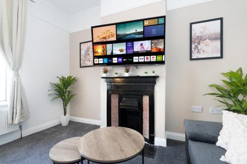 a living room with a fireplace with a flat screen tv at Open Mind Property - 4BR, 17 Guests & Free Parking in Portsmouth
