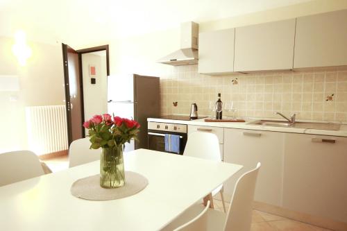 a kitchen with a table with a vase of flowers on it at 6 appartamenti per gruppi fino a 20 persone in Viarigi