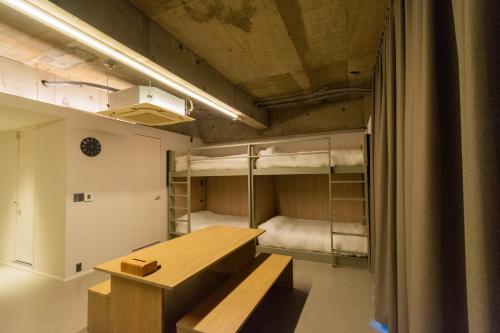 a room with a table and two bunk beds at Visionary Stay HINODE in Tokyo
