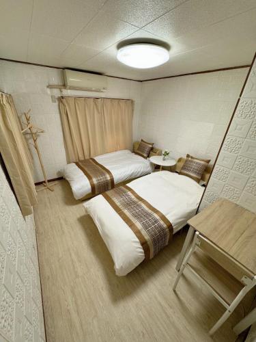a room with two beds and a table in it at 6 minutes to Shinjuku, 10 minutes to Shibuya, accommodating 6 people in Tokyo