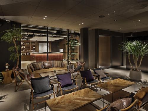 a lobby with chairs and tables and a couch at 30 PIECES Namba in Osaka