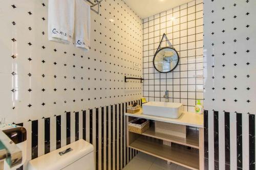 杭州市にある杭州西湖月上兰湾民宿の黒と白のタイル張りの壁のバスルーム
