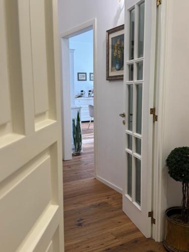 een hal met een witte deur en houten vloeren bij Casa FEREMI in Cavallino di Lecce