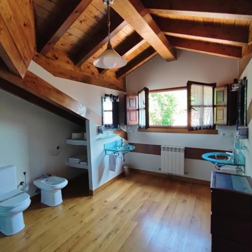 a bathroom with two sinks and a toilet at Apartamentos El Caballar in Sandoñana