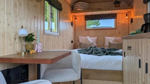 a bedroom in a tiny house with a bed and a desk at CRASH'NSTAY - Mamaloe in Hooge Vaart