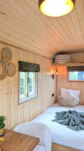 a bedroom with a large bed in a wooden wall at CRASH'NSTAY - Mamaloe in Hooge Vaart