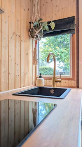 a kitchen with a sink and a window at CRASH'NSTAY - Mamaloe in Hooge Vaart