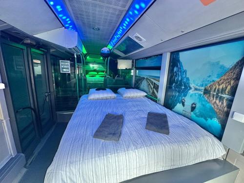 a bedroom with a bed with a painting on the wall at Unusual converted bus for couples or families in Berck-sur-Mer