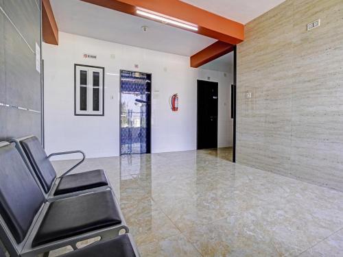 a waiting room with a chair and a wall at Hotel O Gangeshwar in Anand
