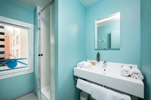 a bathroom with a white sink and a mirror at Ibis Budget Lyon Caluire Cité Internationale in Caluire-et-Cuire