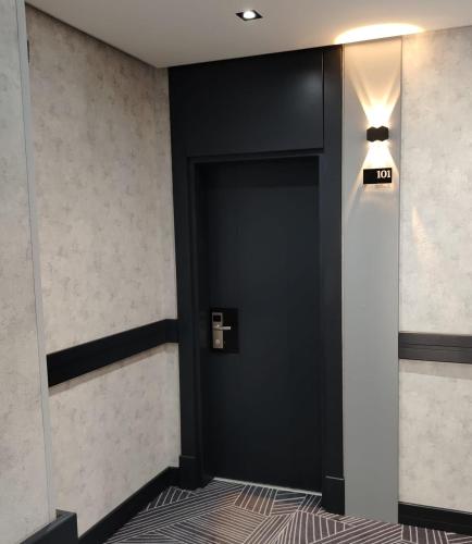 eine schwarze Tür in einem Flur mit einem Schild darauf in der Unterkunft Birinci Hotel in Mingəçevir