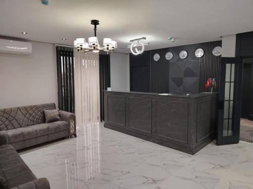 ein Wohnzimmer mit Sofa und Kronleuchter in der Unterkunft Birinci Hotel in Mingəçevir
