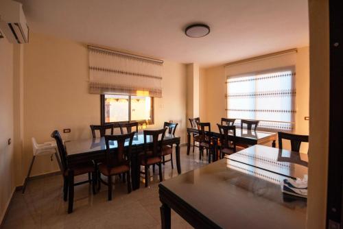 Ramses Tafilah Lodge نزل رمسيس الطفيلة في الطفيلة: غرفة طعام مع طاولات وكراسي خشبية