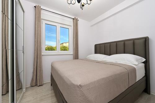 een slaapkamer met een bed en een raam bij Apartment Amarilis in Mandre