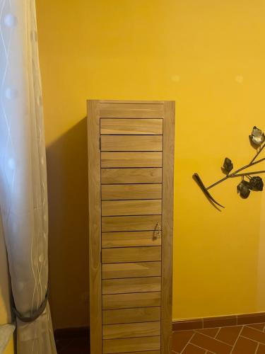 a wooden cabinet in a room with a yellow wall at Torre Verde Acquapendente in Acquapendente