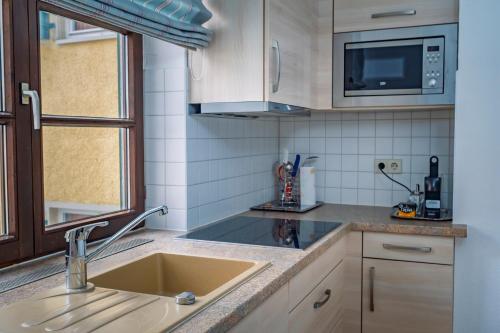 a kitchen with a sink and a microwave at Hotel Obertor in Ravensburg