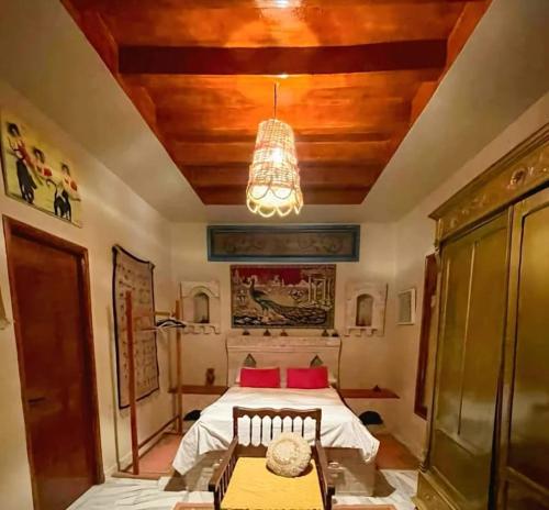 a bedroom with a bed and a chandelier at Villa Dar El Bey in Tozeur