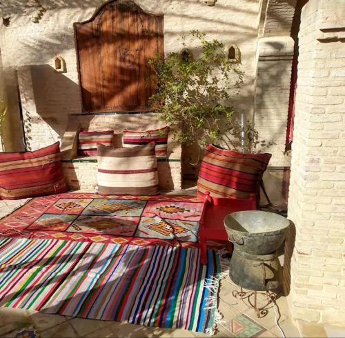 a bedroom with a bed with pillows and a table at Villa Dar El Bey in Tozeur