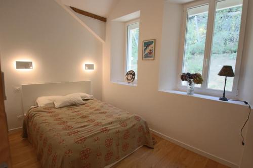 a bedroom with a bed and two windows at Appartement T5 145m2 4 chambres, vue lac climatisé in Tresserves