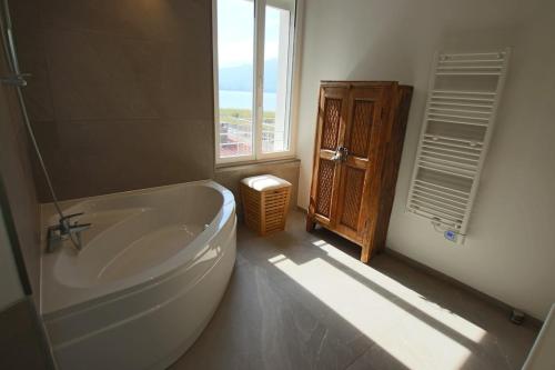 a bathroom with a large tub and a window at Appartement T5 145m2 4 chambres, vue lac climatisé in Tresserves