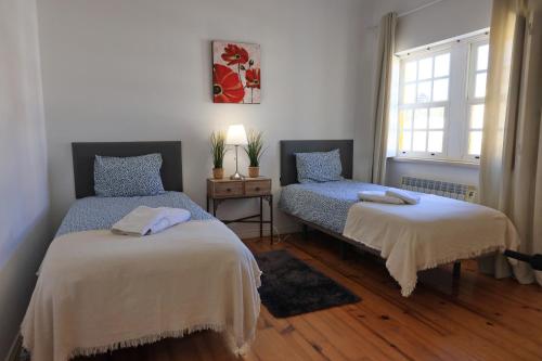 a bedroom with two beds and a window at Villa Ericeira in Ericeira