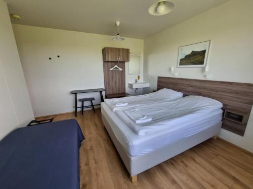 una camera da letto con un letto grande e un tavolo di Litla-Hof Guesthouse a Hof