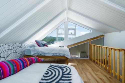 a attic room with two beds and a window at The White House - Kleinkrantz in Wilderness