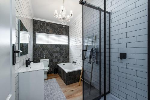 a bathroom with a sink and a toilet and a tub at The White House - Kleinkrantz in Wilderness