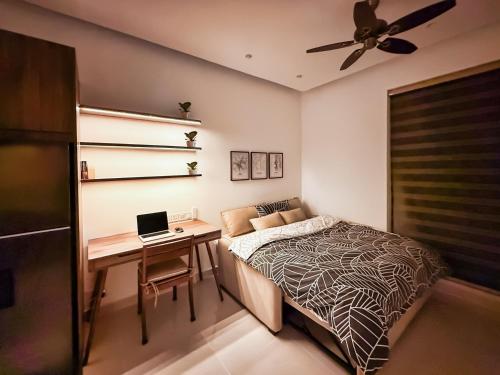 a bedroom with a bed and a desk with a laptop at Hygge Haven Saigon in Ho Chi Minh City